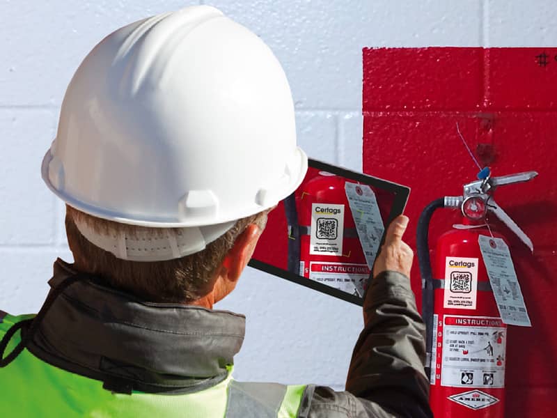 Man inspecting fire hydrant with tablet